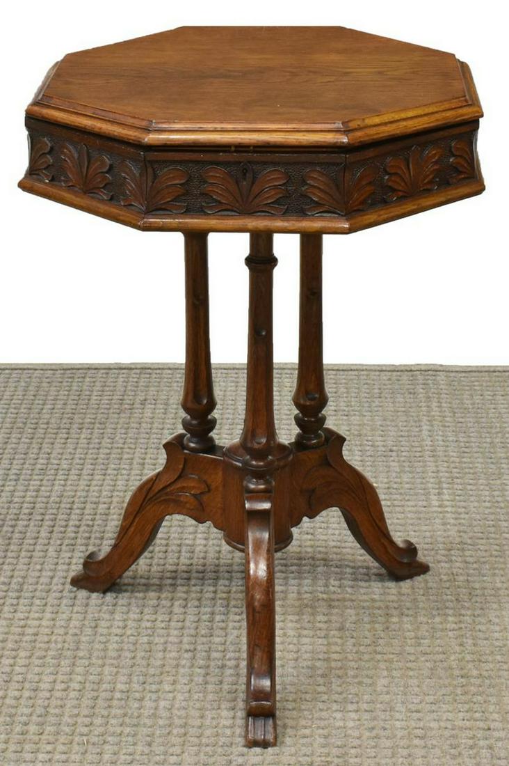 ENGLISH VICTORIAN CARVED OAK SEWING TABLE: English Victorian carved oak sewing table, mid 19th c., octagonal hinged top with foliate carved border, opening to compartmentalized interior, rising on turned standards, terminating on tripod base, 