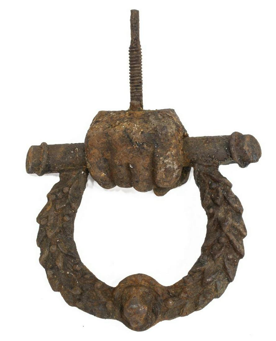 GEORGIAN ARCHITECTURAL CAST IRON DOOR KNOCKER: English Georgian architectural cast iron door knocker, early 19th c., in the shape of fist hanging from horseshoe shaped knocker with lion head and foliated wreath, oxidation with remnants of paint, a