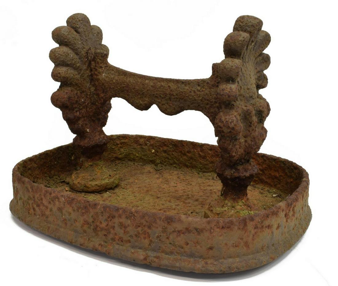 ANTIQUE ENGLISH CAST IRON BOOT SCRAPER: English cast iron boot scraper, mid 19th c., center bar supported by shell-form supports, on oval base with raised edge, oxidation, approx 9.5"h, 13.5"w, 10.5"d, 25.5lbs Start Price: $80.00