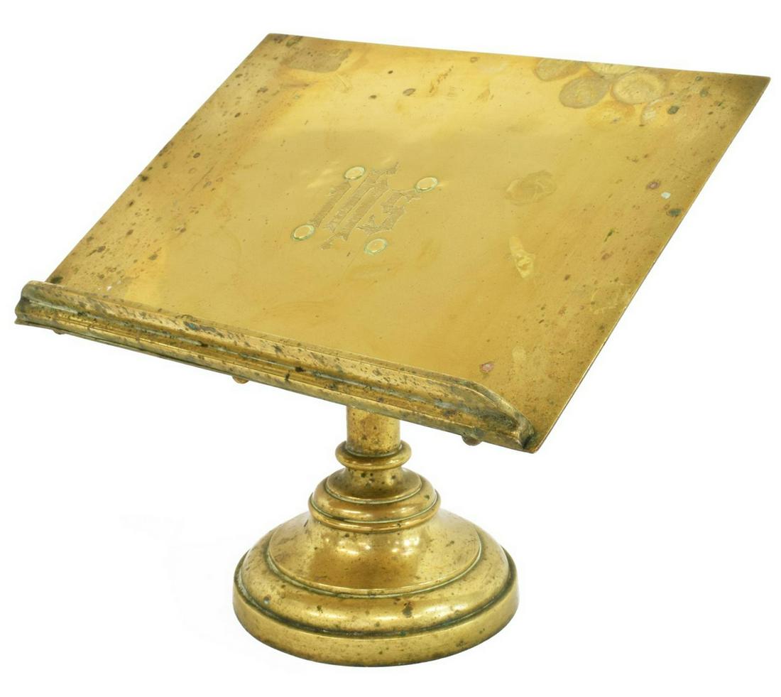 ENGLISH RELIGIOUS BRASS TABLETOP MISSAL STAND: English tabletop brass lectern/ bookstand, early 20th c., engraved with Christogram IHS over book ledge, rising on an iron-weighted pedestal base, approx 9.5"h, 11"w, base: approx 5 3/8"diam, 5.5lbs S