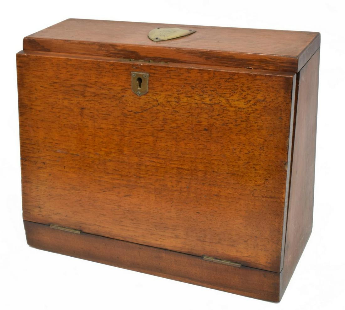 ENGLISH EDWARDIAN OAK TRAVELING STATIONARY BOX: English Edwardian oak stationary desk box, early 20th c., the lift top mounted with monogrammed presentation plaque of shield form, slant front opens to leather-lined interior, with cubbies, slots and
