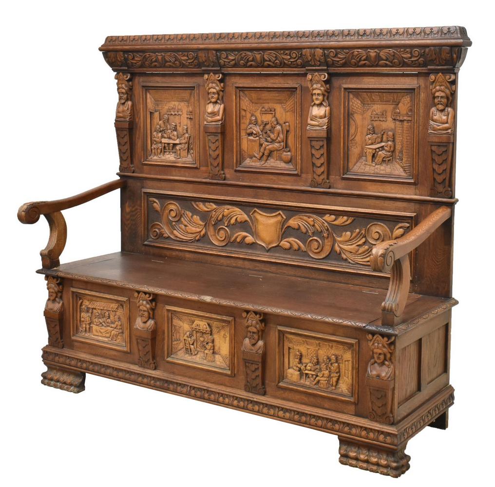 CONTINENTAL OAK HALL BENCH CARVED TAVERN SCENES: Continental oak hall bench, 19th c., raised back with foliate and shield carved frieze, figural pilasters, reserves with tavern scenes, scrolling foliate handholds, hinged bench seat with open storage
