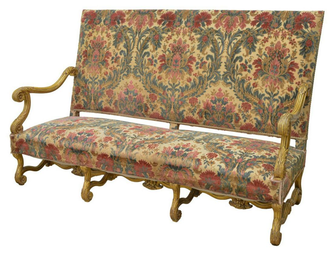 FINE FRENCH LOUIS XIV STYLE GILTWOOD SOFA SETTEE: French Louis XIV style sofa, giltwood frame with scrolled acanthus arms, upholstered high back over bench seat, rising on volute supports, joined by H stretcher with floral carving, restoration to one