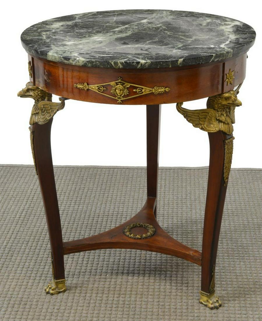 EMPIRE STYLE ORMOLU-MOUNTED MAHOGANY GUERIDON: French Empire style mahogany table, late 19th c., circular marble top, ormolu-mounted apron with Mercury mask, three legs with eagle mounts, joined by shaped center stretcher, ending in paw feet, lift