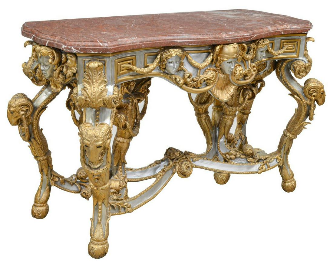 BAROQUE STYLE MARBLE-TOP GILT CONSOLE TABLE: Baroque style console table, 20th c., shaped marble top, over silver and gold gilt painted metal frame, with molded masks and laurel garlands, scrolled legs with rams' heads, elaborate center stretche