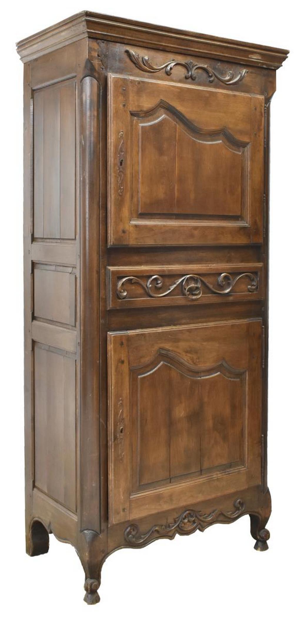 FRENCH PROVINCIAL LOUIS XV STYLE WALNUT BONNETIERE: French Provincial Louis XV style walnut bonnetiere, 19th c., molded cornice, frieze with scrolling foliates in relief, fitted with two paneled doors on exterior hinges, centering medial drawer, shaped