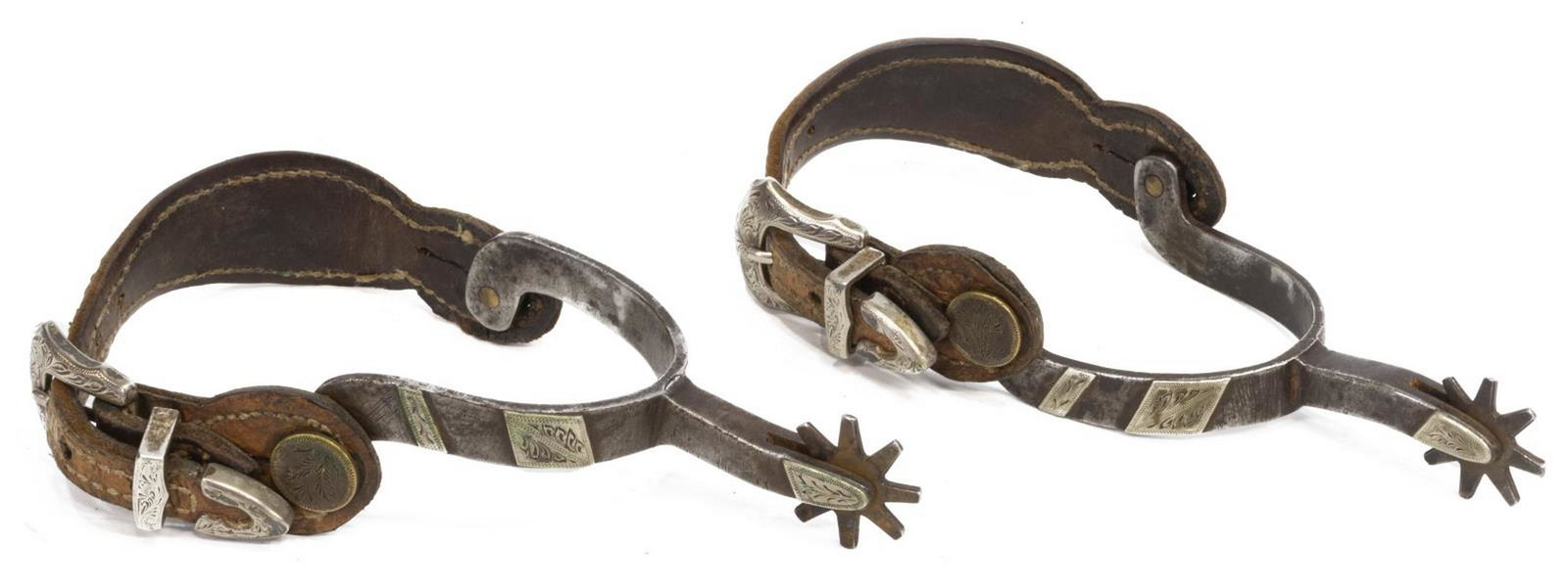 (PAIR) SILVER-MOUNTED COWBOY SPURS: (pair) Silver-mounted cowboy spurs, 20th c., 8 point rowels, the inside button each etched with a swastika, tooled leather straps with three piece buckle sets, inside yoke approx 3.25"w, 3.5"d Start P
