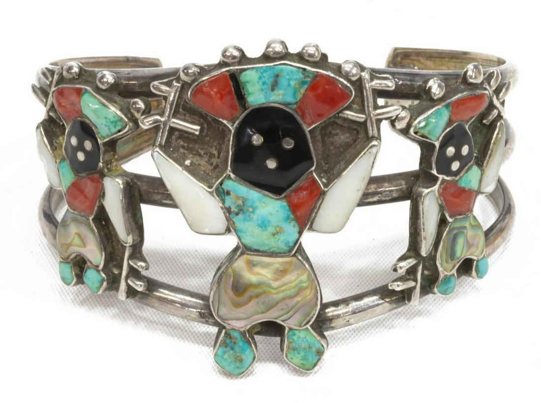 ZUNI SILVER INLAID APACHE CROWN DANCER CUFF: Native American silver (content unknown) multi-stone inlaid cuff bracelet, Apache Crown Dancers, Zuni, illegibly signed, #570, the figures with inlays of shell, abalone, red coral, and turquoise, on a