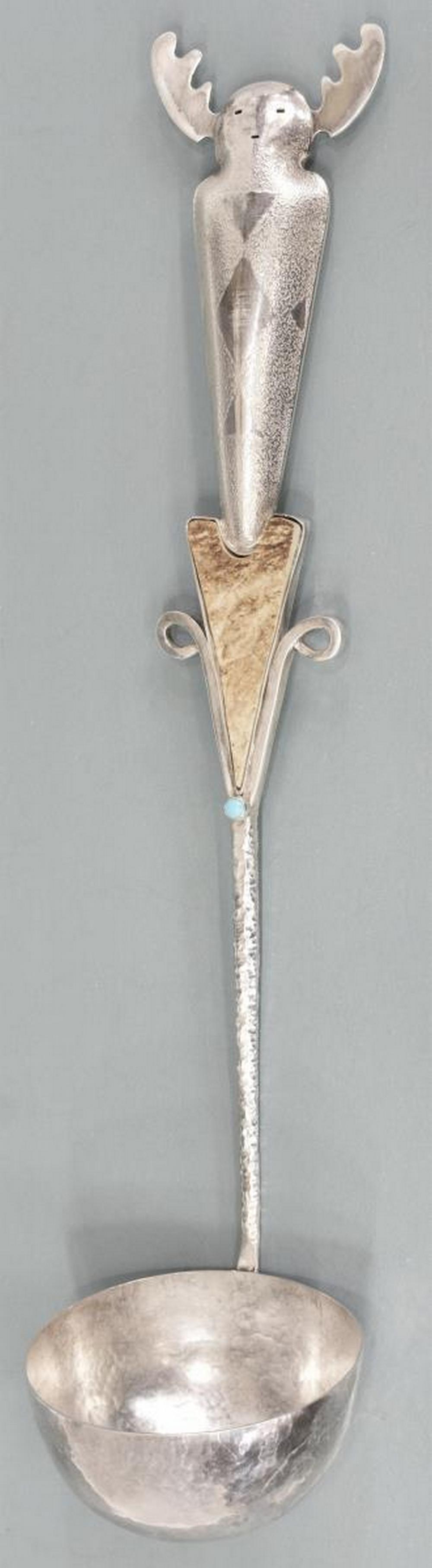 SPECTACULAR NATIVE AMERICAN STERLING LADLE, LLM: Spectacular Native American sterling silver ladle, stamped LLM, stylized masked figure with antlers, over inlaid antler plaque, Sleeping Beauty turquoise cabochon, hammered stem and bowl, approx 15.5"