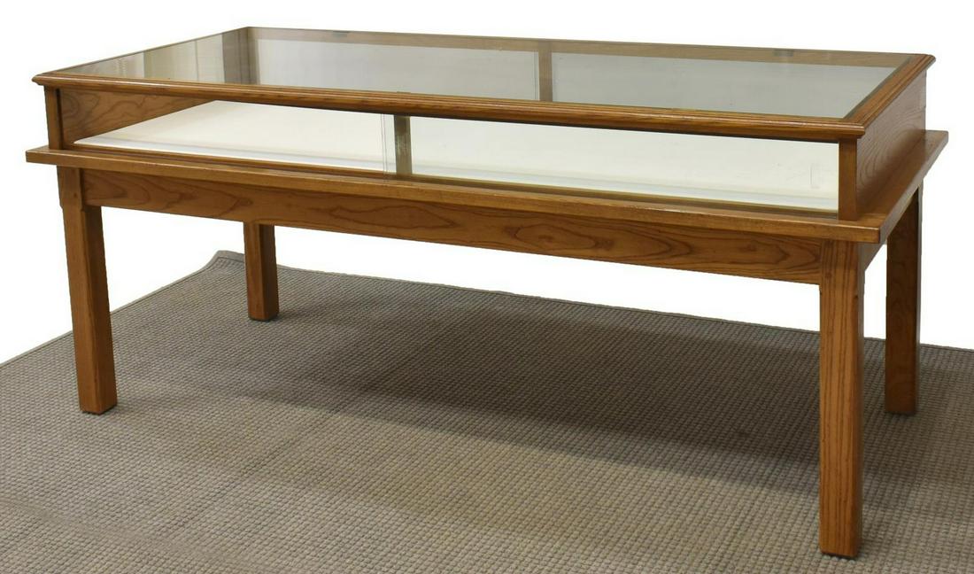 JAMES AVERY OAK FRAMED STORE JEWELRY DISPLAY TABLE: James Avery oak framed store display table, 20th c., an inset glass top over the open display area, sliding glass door entry at two sides, rising on squared legs, 36"h, 84"w, 36"d Start Price: $200.00