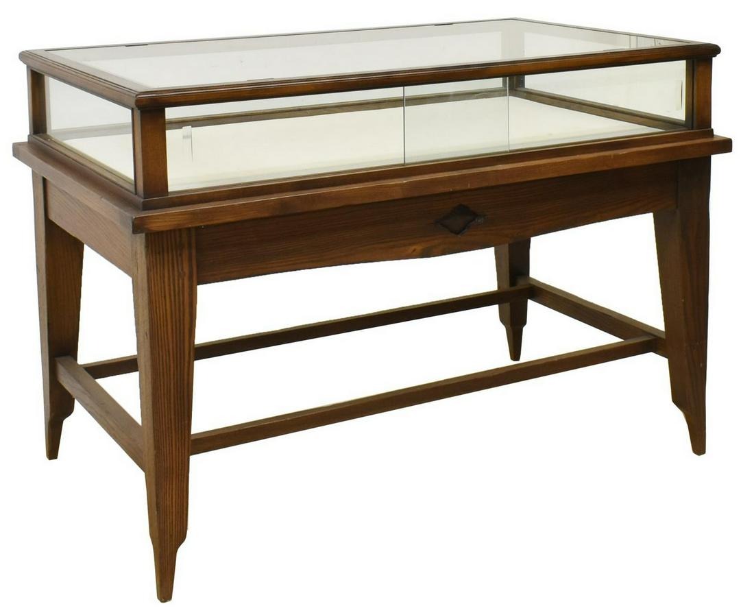 JAMES AVERY OAK FRAMED STORE DISPLAY TABLE: James Avery oak framed store display table, 20th c., an inset glass top over the open display area, sliding glass door entry at two sides, rising on squared legs, approx 37"h, 50.5"w, 30.5"d Start Pri