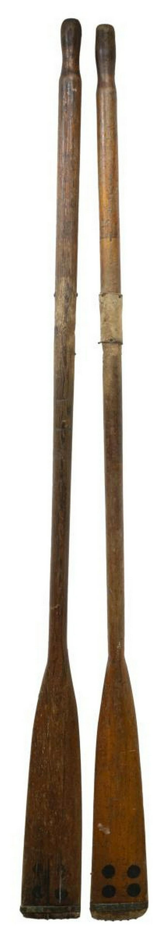 (2) WOODEN BOAT OARS: (lot of 2) Wooden boat oars, each of similar style, having visible metal hardware, including: (1) with leather grip, (1) split to wood; each approx 77"l, 5"w Start Price: $50.00