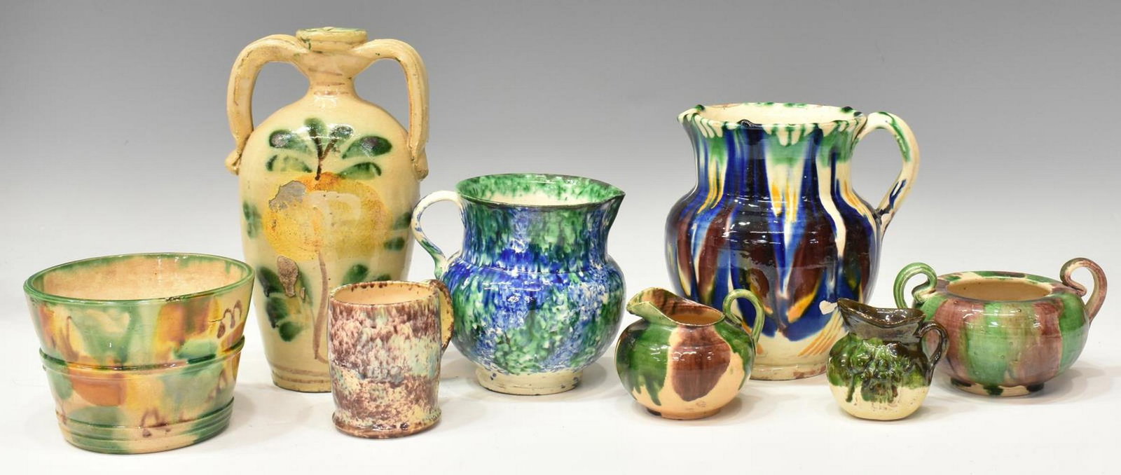 (8) COLLECTION OF GLAZED EARTHENWARE POTTERY: (lot of 8) Collection of polychrome glazed earthenware pottery, highlights include: (1) double-handled jug, with green and yellow glazed flower motif, approx 8 3/8"h, (1) small butter crock, with mott