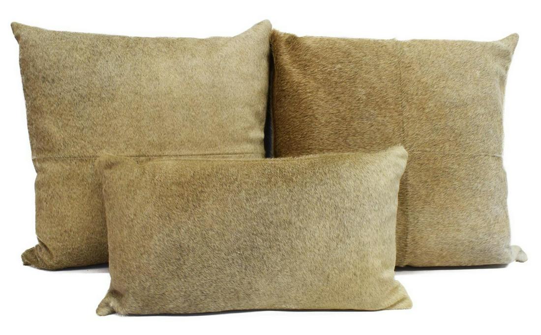 (3) DECORATIVE COWHIDE THROW PILLOWS: (lot of 3) Decorative cowhide pillows, largest: approx 20"h, 21"w; 14.75lbs total Start Price: $50.00