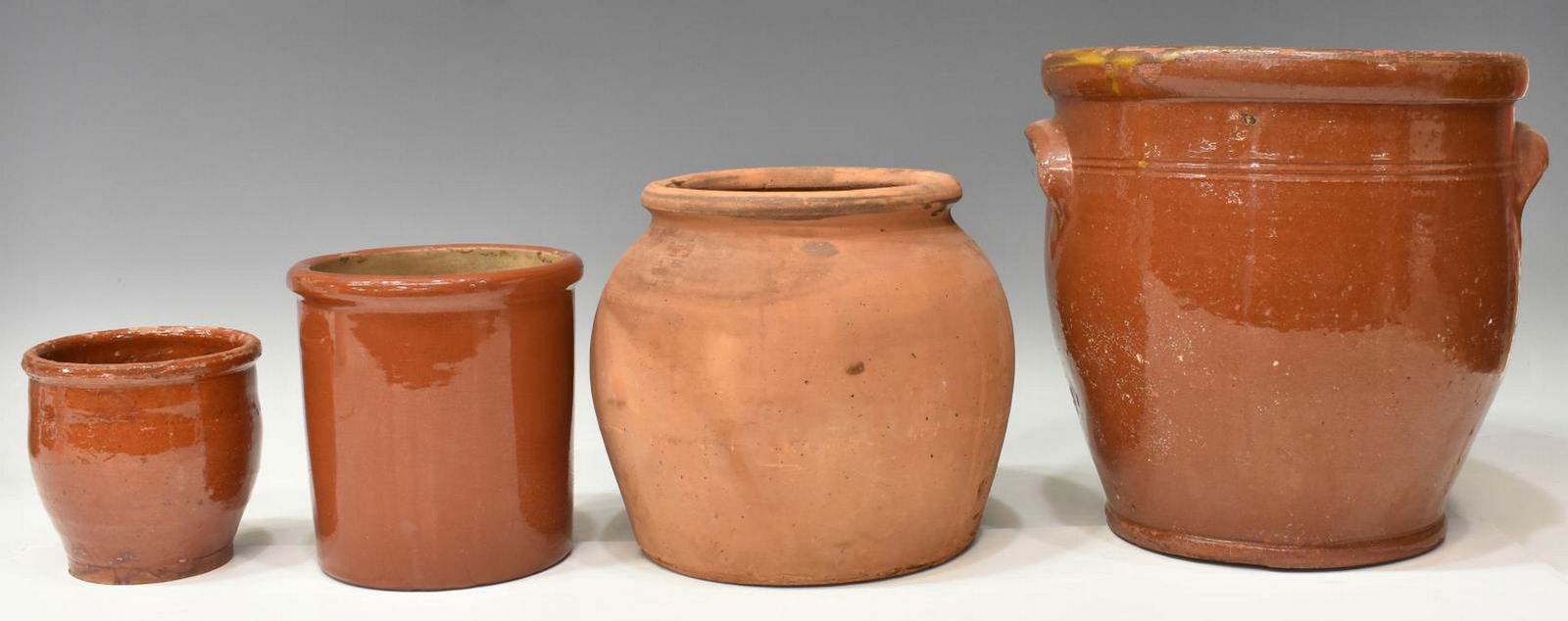 (4) AMERICAN REDWARE POTTERY CROCKS & JARS: (lot of 4) American redware pottery, late 19th/ early 20th c., including: (1) crock, with applied handles, two lines circle body, wear to interior, chipping and crazing to glaze, approx 10"h, 10.5"dia
