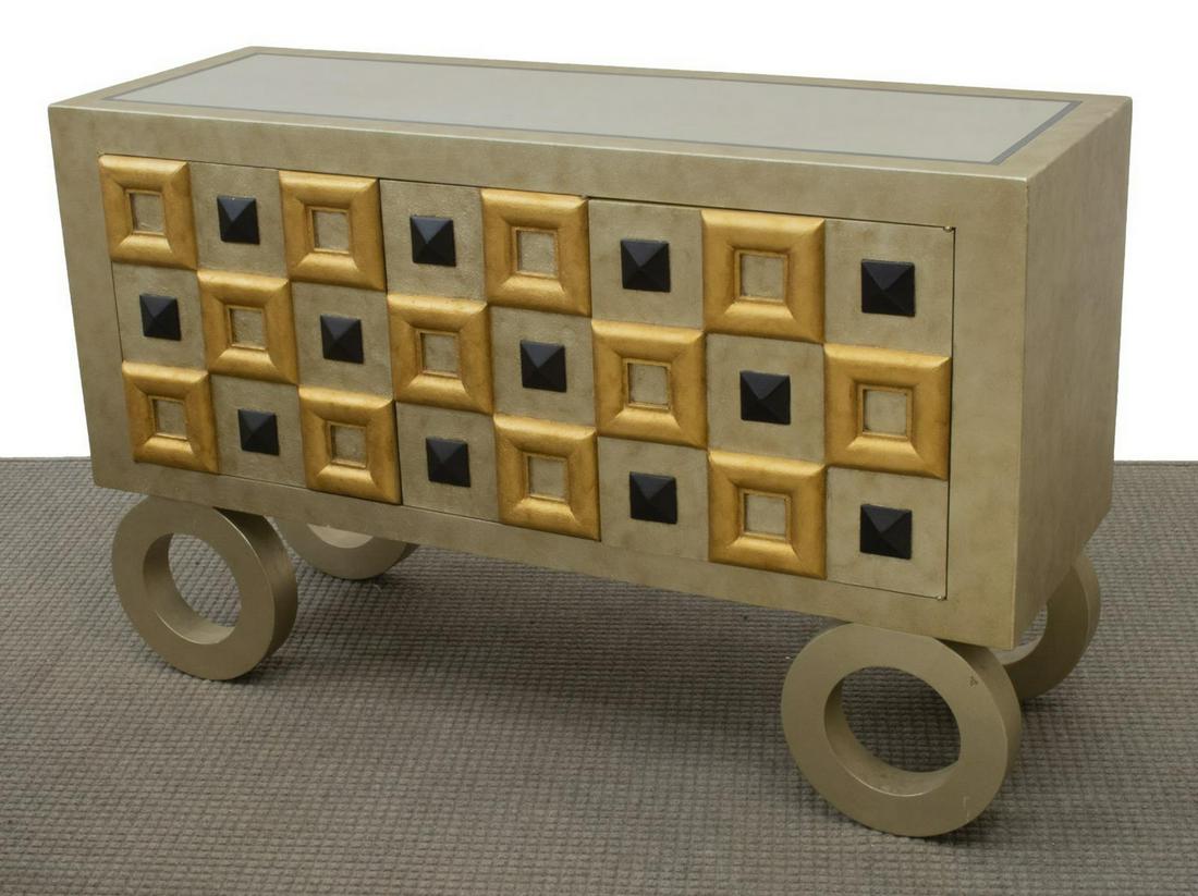 CONTEMPORARY GILT FINISH CREDENZA CONSOLE CABINET: Contemporary credenza/ console cabinet, late 20th c., rectangular case in silver and gold gilt finish, three cabinet doors with geometric paneling, interior shelf, rising on open circular supports, ap