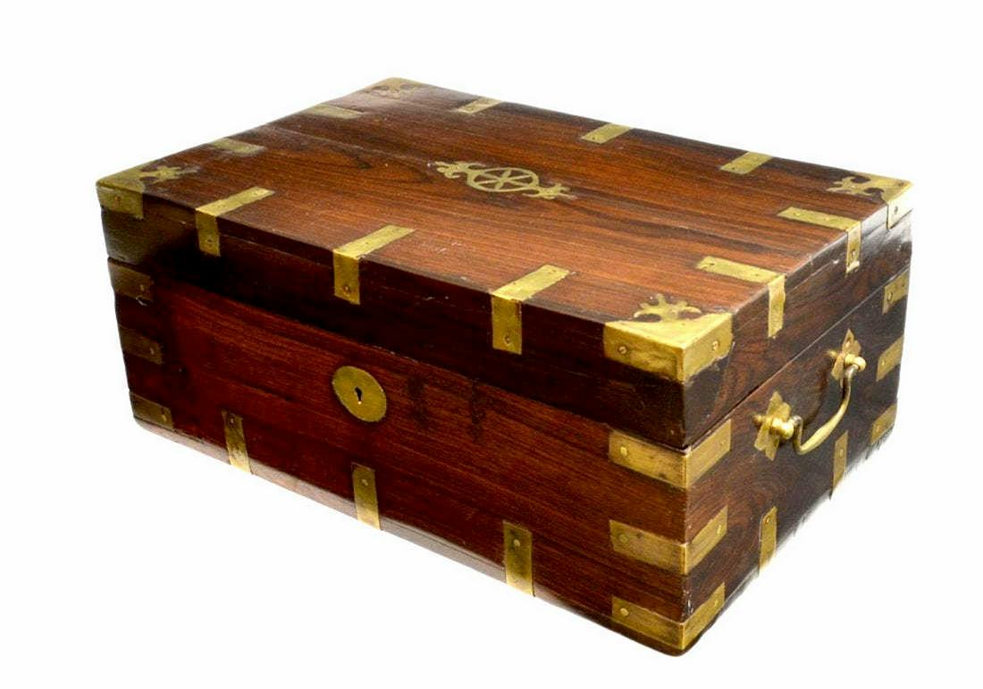 BRITISH COLONIAL BRASS-BOUND FITTED TRAVEL BOX: Large British Colonial brass-bound rosewood travel box, c.1900, side carrying handles on the brass-mounted box of rectangular form, fitted interior with removable tray and concealed drawers, old split