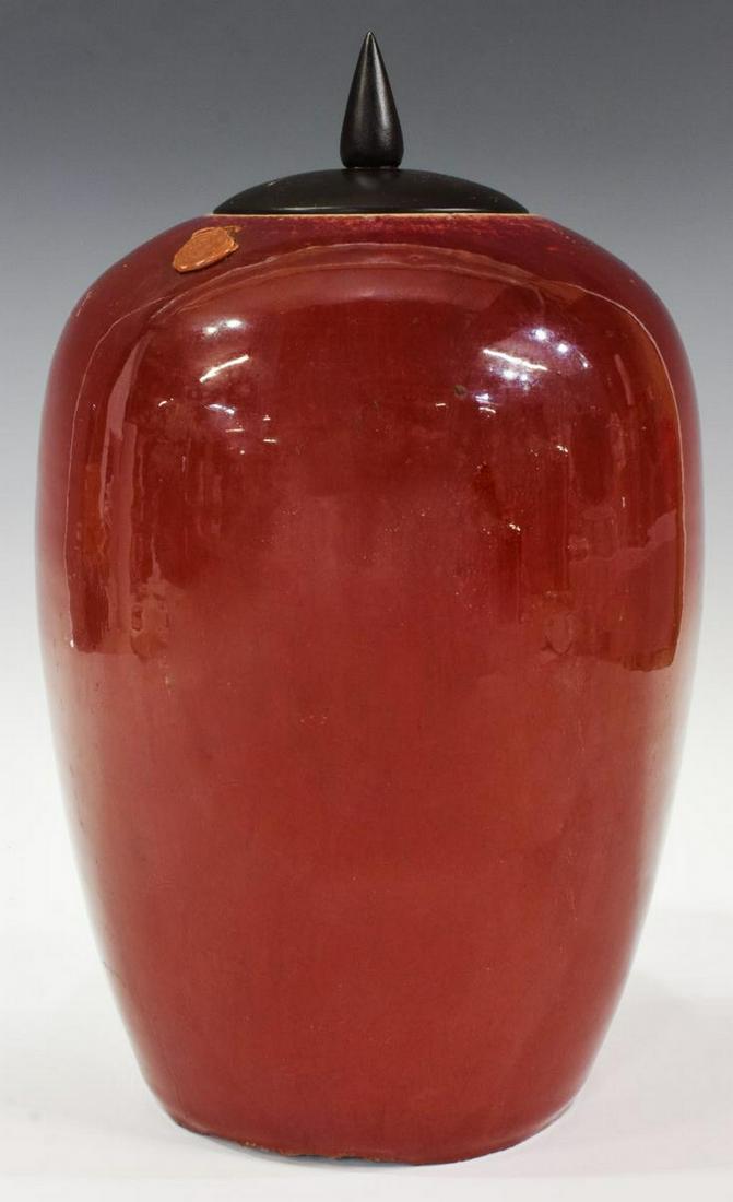 CHINESE OX BLOOD GLAZED COVERED MELON JAR: Chinese ox blood red glazed melon jar, having wood lid, retaining remnants of seal to side, chips underfoot as pictured, approx 13"h, 6"diam, 6lbs Start Price: $60.00