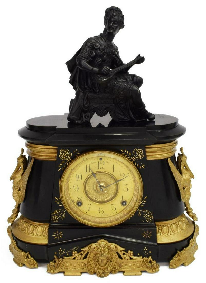 ANSONIA NY 'POMPEII' CAST IRON MANTEL CLOCK: American mantel shelf clock, Ansonia Clock Company, New York, c.1902, patinated metal figural topper of a troubadour, over parcel gilt cast iron case with stylized birds at sides, beveled glass dial w