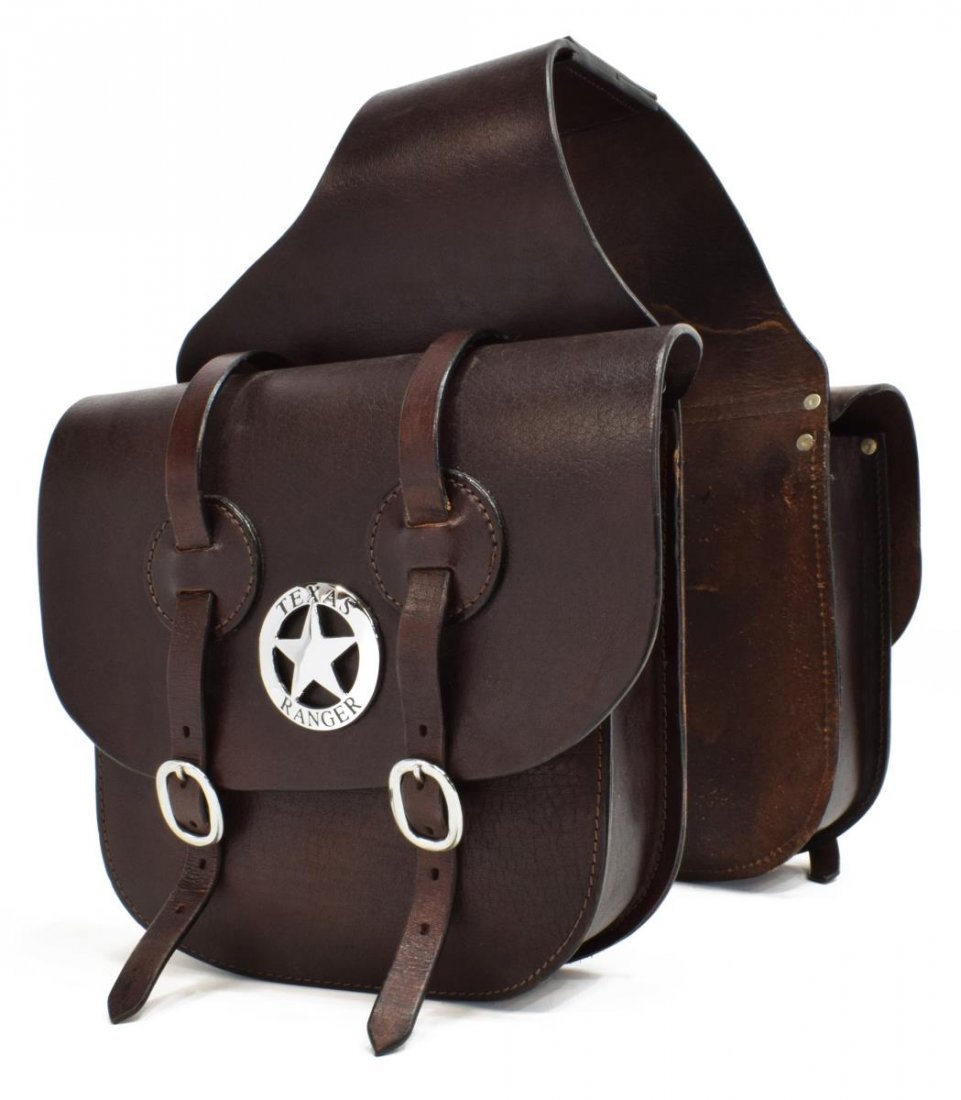 WESTERN LEATHER SADDLE BAGS, LIKE NEW: Western leather saddle bags appearing as never used, chromed hardware including two oversize facsimiles of Texas Rangers badges, each bag approx: 12"h,13"w, 4"d, length when laid flat: approx. 43"