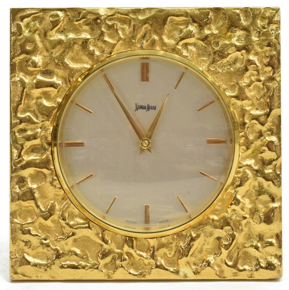 SWISS-MADE DESK CLOCK RETAILED BY NEIMAN MARCUS: Swiss-made desk clock, possibly Jaeger Lecoultre, retailed by Neiman Marcus, Brutalist-inspired textured gilt metal frame, dial with baton indexes, fifteen jewels, easel back, serial number 1373068, a