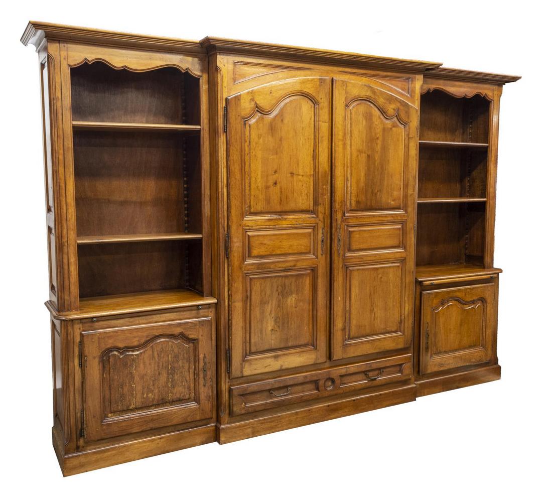 FRENCH PROVINCIAL WALNUT BOOKCASE: French Provincial walnut armoire/ bookcase, in three units, 20th c., having central armoire, with crown molding, dual paneled doors, scrolling escutcheon, opening to adjustable interior shelves, over 