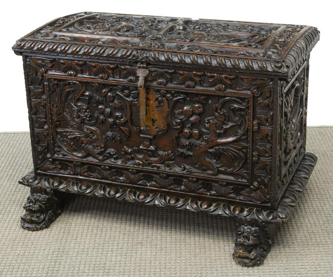 RENAISSANCE REVIVAL CARVED OAK TRUNK, 19TH C: Renaissance Revival oak trunk, 19th c., heavily carved with griffins and fruit branches, hinged top opens to interior till with carved storage compartment, rising on lion's mask feet, approx 28"h, 41"