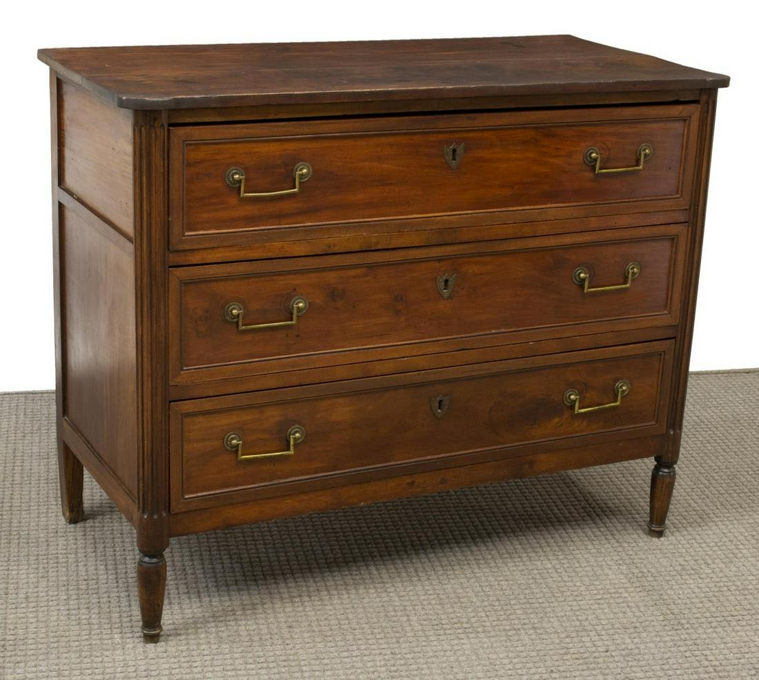 FRENCH LOUIS XVI PERIOD WALNUT COMMODE: French Louis XVI period walnut commode, 18th c., the top with protruding front corners over three drawers flanked by ribbed columns, descending to tapered legs, approx 35"h, 43.75"w, 21"d Start Price: