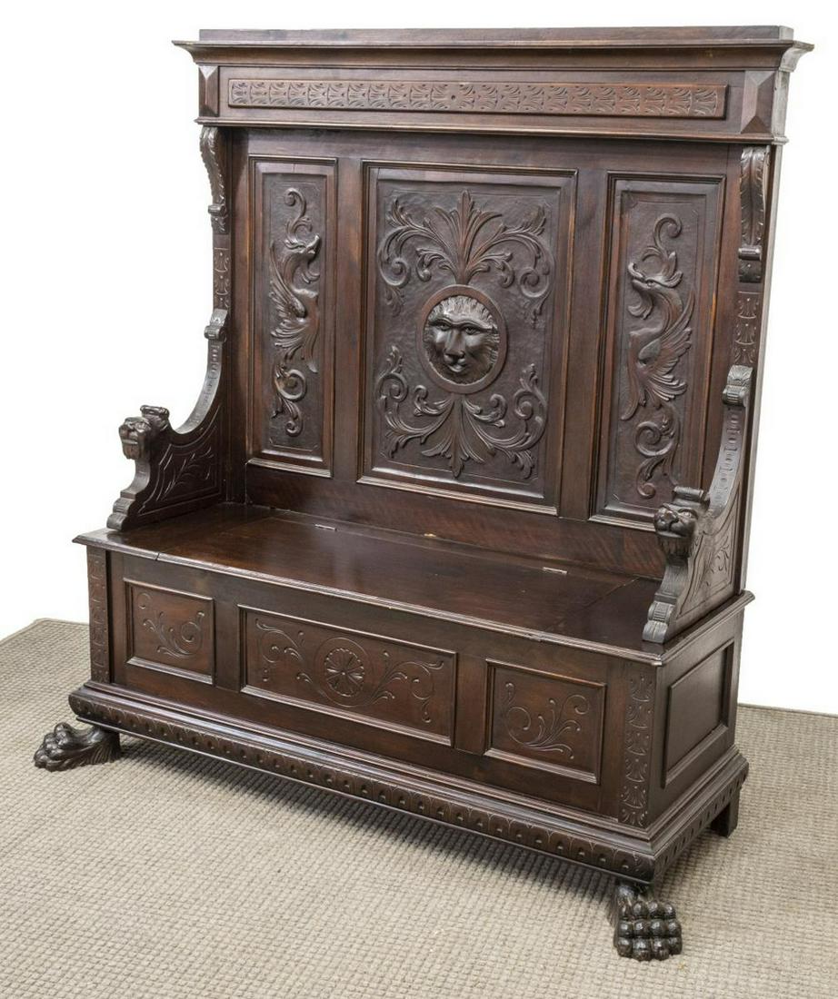RENAISSANCE REVIVAL FIGURAL CARVED HALL BENCH: Italian Renaissance Revival figural carved hall bench, 19th c., molded cornice, paneled back carved with scrolling foliates, lion heads and griffins, arms with grotesque mask terminals, atop hinged se