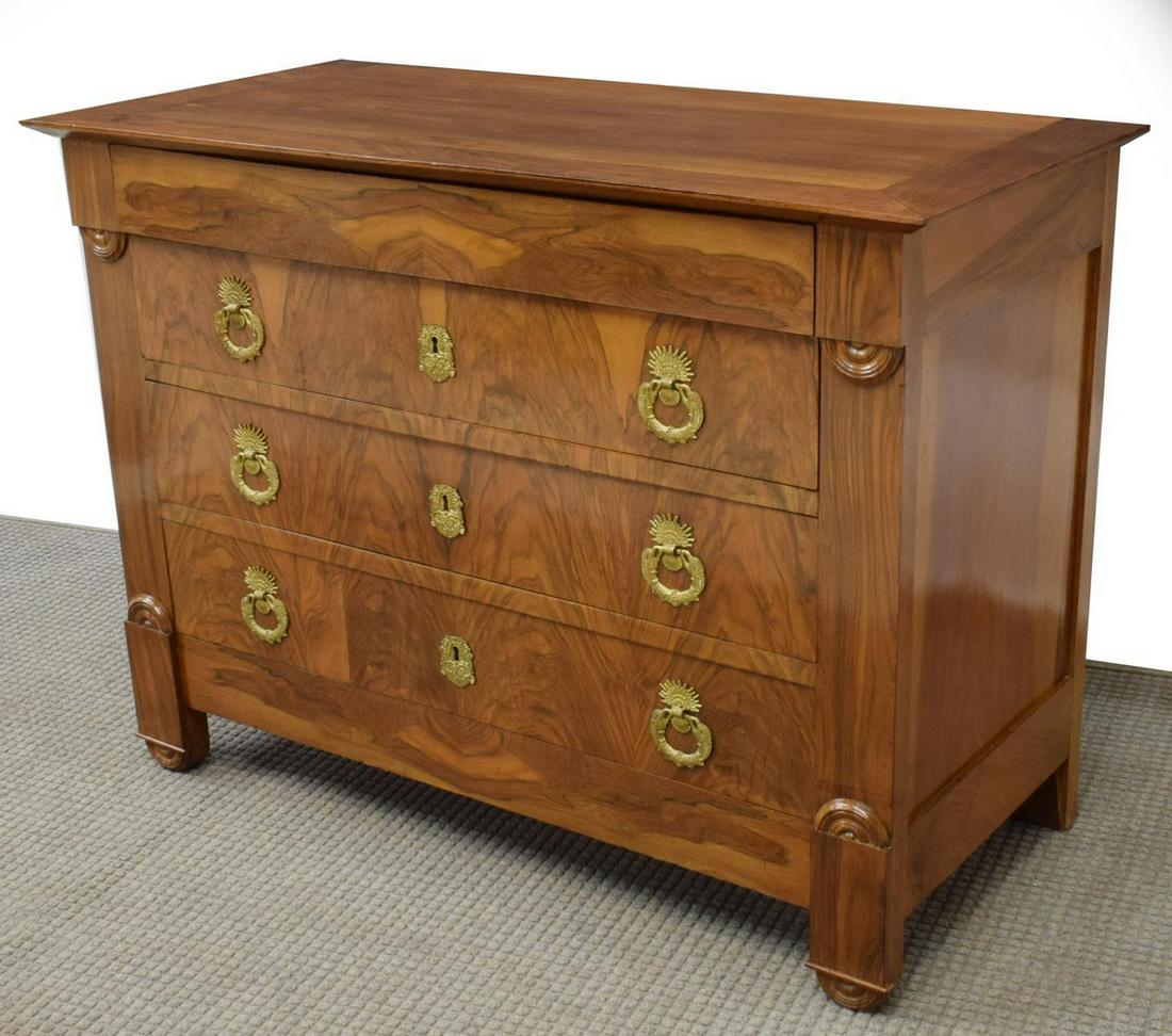 FRENCH EMPIRE STYLE FIGURED WALNUT COMMODE: French Empire style walnut commode, 19th c., case in bookmatched figured veneers, concealed drawer in frieze, over three additional drawers with gilt metal swan pulls, rising on molded circular feet, 
