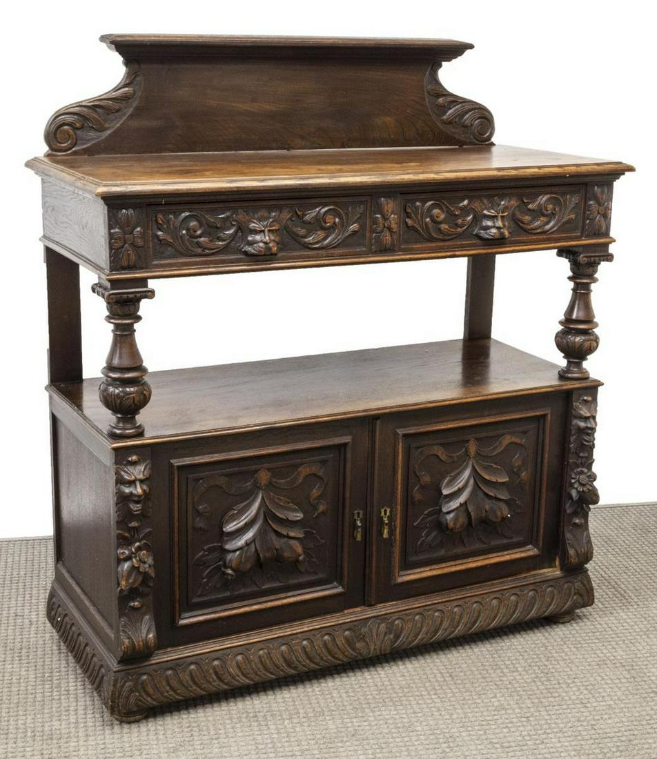 FRENCH HENRI II STYLE RELIEF CARVED OAK SERVER: French Henri II style oak two-tier sideboard/ server, 19thc., raised backsplash, rectangular top with molded edge, over dual drawers with mask pulls, on columnar supports, open medial shelf, over doub