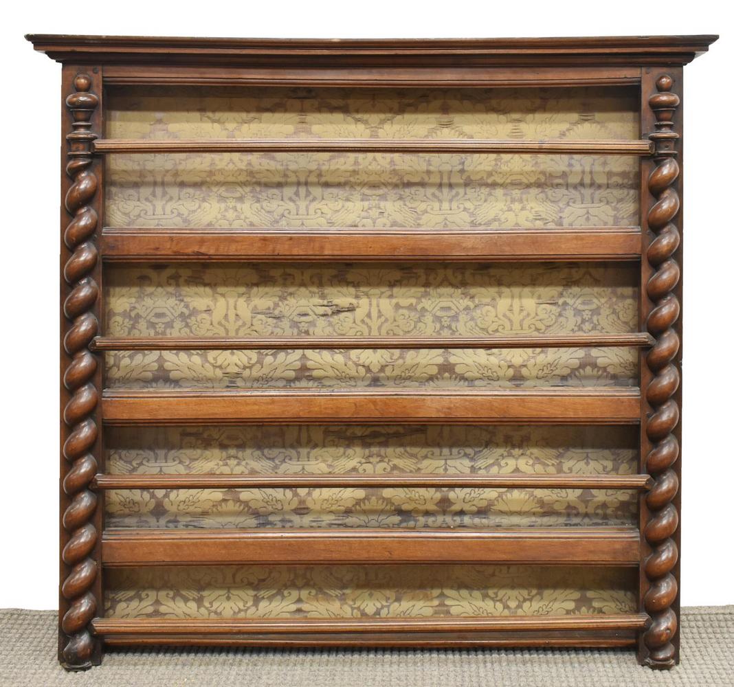 FRENCH WALNUT WALL HANGING PLATE RACK: French walnut wall hanging plate rack, the corniced top over four shelves, flanked by Solomonic columns, fabric on back panel, having metal wall hooks, approx 50.5"h, 57.75"w, 6.75"d Start Price: $100