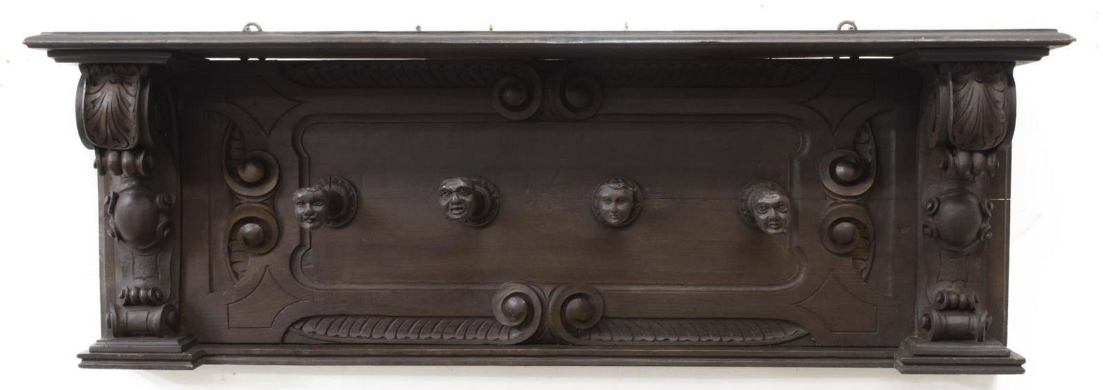 ITALIAN RENAISSANCE REVIVAL WALNUT HAT RACK: Italian Renaissance Revival walnut hat rack, early 20th c., having running ornamentation at top, scrollwork and foliate carving, four hooks, terminating in carved figural heads, approx 16.5"h, 47"w, 8