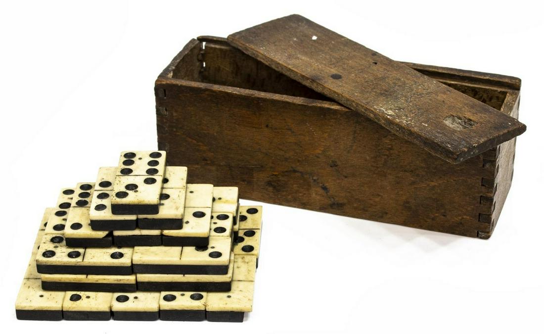 CIVIL WAR ERA TWO PIN DOMINOE SET: Civil War era dominoes housed in dove tailed wood box with wood slide top, 28 white bone on ebony tiles joined by a pin at each end, some with cracks, one chipped, each approx 0.75" x 1 5/8", wood box
