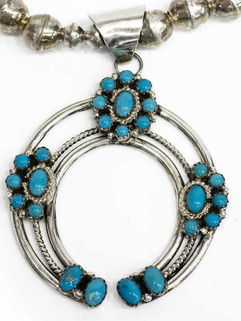 NILA COOK NATIVE AMERICAN TURQUOISE NAJA NECKLACE: Native American sterling silver necklace, Nila Cook (Navajo, 20th c.), bench and melon beaded strand, central naja pendant set with Sleeping Beauty turquoise cabochons, bail stamped NC sterling, appro