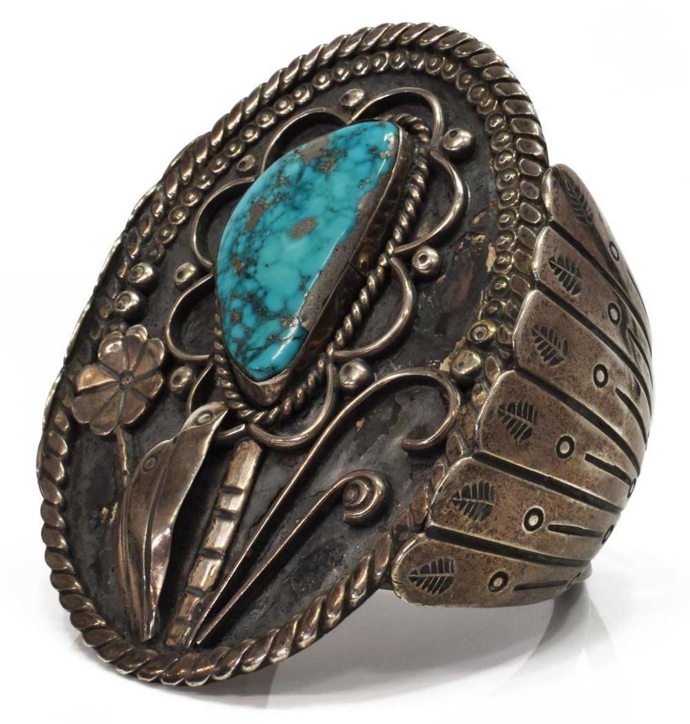NATIVE AMERICAN MORENCI TURQUOISE CUFF BRACELET: Native American silver (content unknown) cuff bracelet, central bezel-set Morenci turquoise with silver colored iron pyrite matrix, modeled as the center of a flower, stamped shoulders, approx 3.25"w,