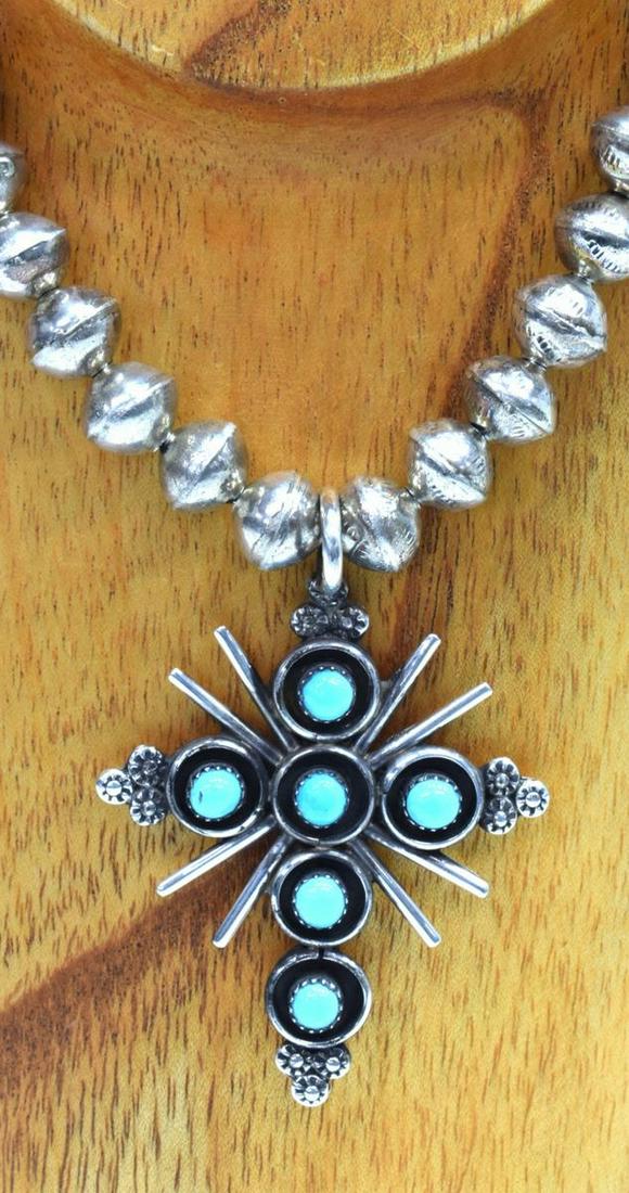 TERRY DISHTA ZUNI SILVER TURQUOISE CROSS NECKLACE: Native American silver (content unknown) necklace, cross-form pendant, signed T. Dishta (Terry Dishta, Zuni, New Mexico), with six bezel-set turquoise cabochons, radiating spikes, on assembled bench b