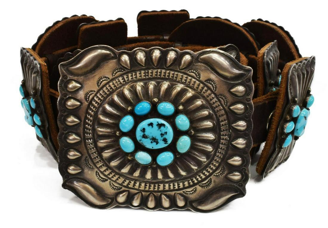 DANIEL MARTINEZ NAVAJO TURQUOISE CONCHO BELT: Native American sterling silver concho belt, Daniel Martinez (Navajo, 20th c.), oval and rectangular stamped conchos, all set with turquoise cabochons, on a brown leather belt, lacking (one) small tur