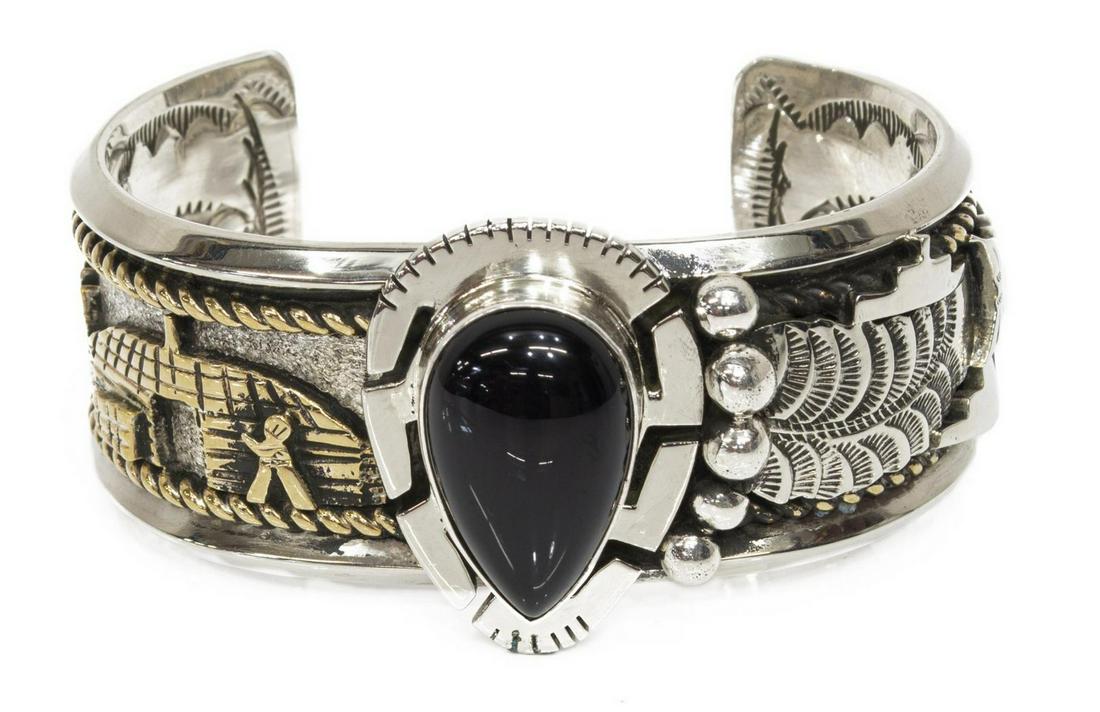 ROGER NELSON STERLING 12K GF STORYTELLER CUFF: Native American sterling silver and 12kt gold fill cuff bracelet, Roger Nelson (Navajo, 20th c.), pear-shape black onyx, storyteller figural scene, approx 1 3/8"w, interior: (end to end) approx 5.5"l,
