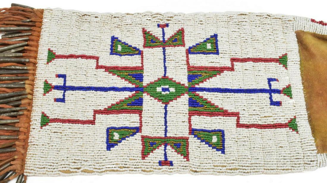 CHEYENNE OR LAKOTA SIOUX BEADED TOBACCO BAG: Cheyenne or Lakota Sioux beaded tobacco bag, c. 1900-1910, beaded geometric designs, with white, red, blue, green, and gold-tone trade beads, quilled ties, twisted fringe edge with metal conical beads