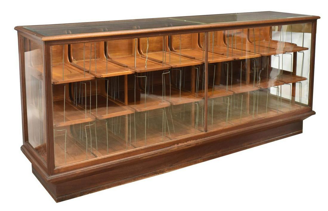AMERICAN GENERAL STORE 8' OAK DISPLAY COUNTER: American general store counter, early 20th c., rectangular oak case, top with two beveled glass insets, glazed front and side panels, twenty four pull-out drawers, rising on a plinth base, approx 42"h