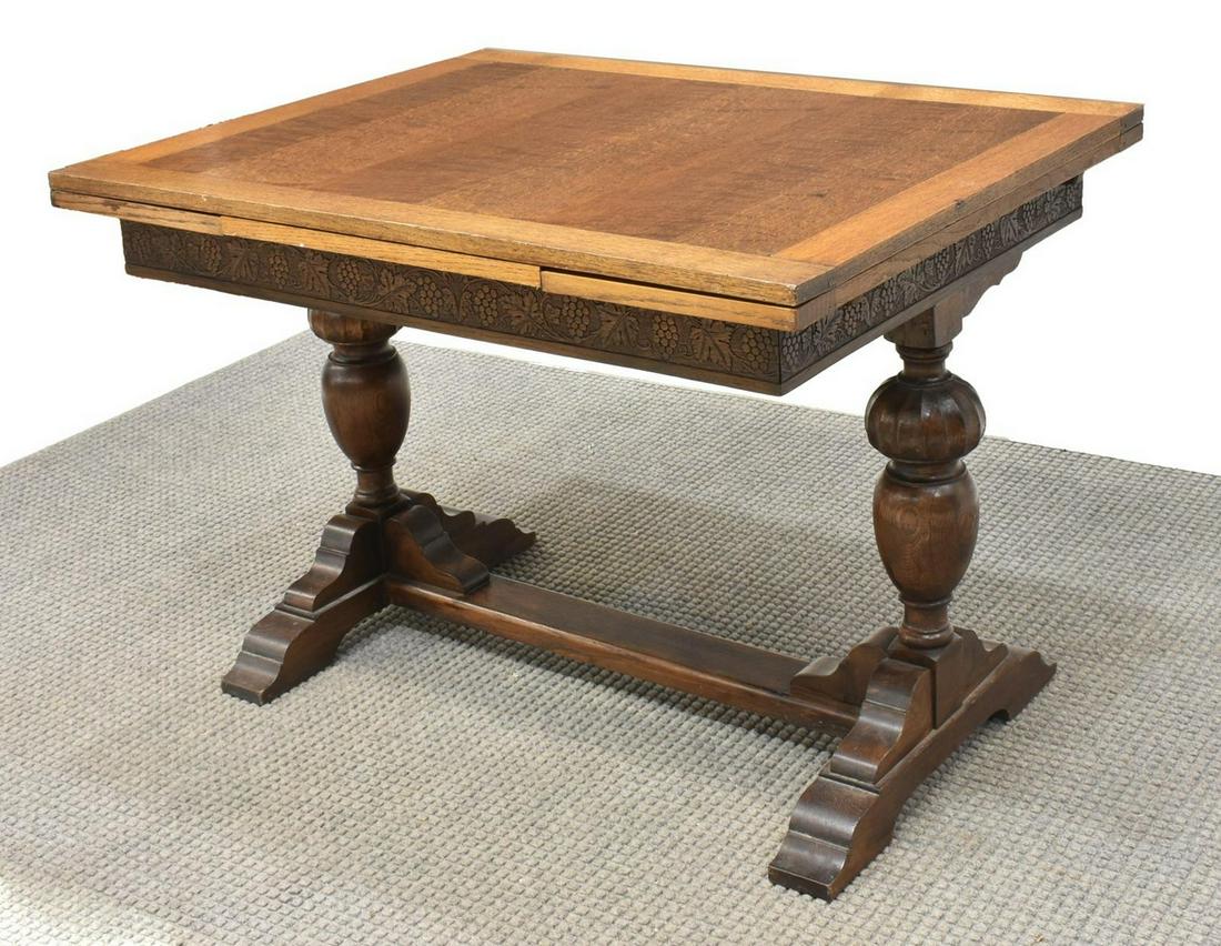 ENGLISH CARVED OAK DRAW LEAF TAVERN TABLE: English oak tavern table, early 20th c., rectangular tabletop with draw leaves, apron carved with grapevine motif, bulbous melon cap supports, on a shoe foot trestle base, approx 29.5"h, 42"w, 33"w, e