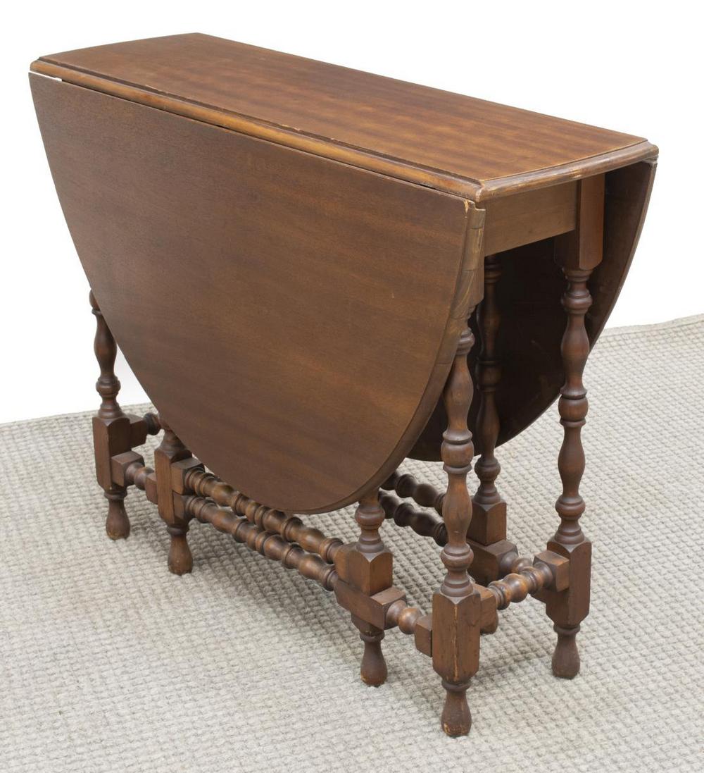 ENGLISH MAHOGANY DROP-LEAF GATELEG TABLE: English mahogany drop-leaf table, 20th c., having oval top, with drop leaves, opening over adjustable turned supports, all rising on stretcher-joined turned supports, restoration to one side support,