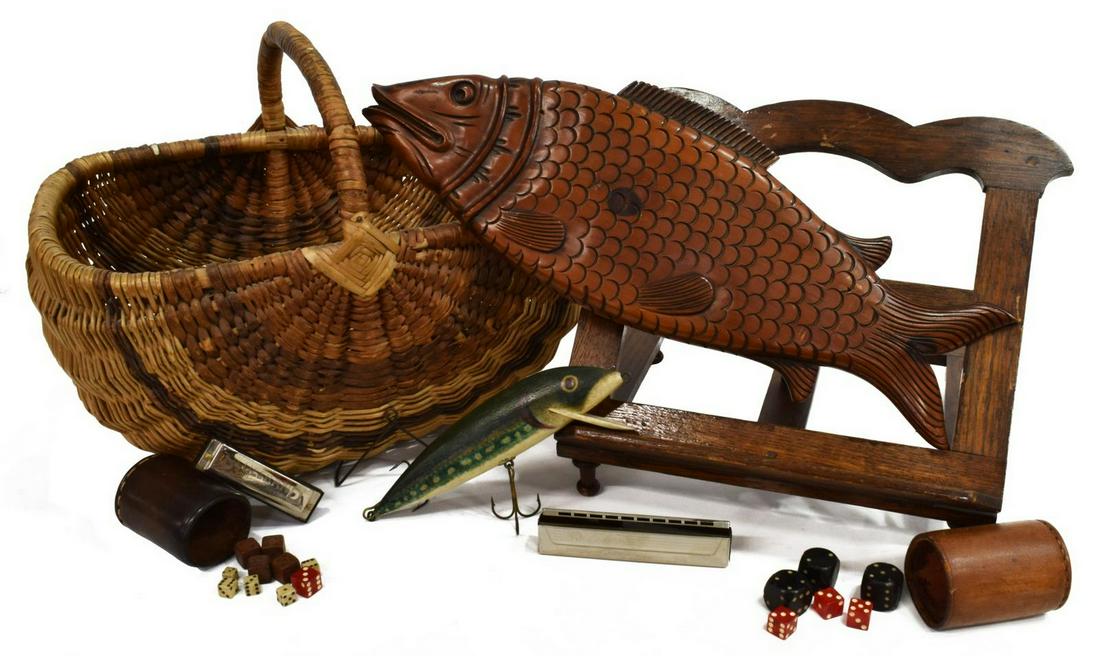 LOT) LEATHER DICE CUPS, HARMONICAS, BOOKSTAND, ETC: (lot) Collectible group: (1) Echo Hohner harmonica; (1) Blues Band harmonica; (2) leather dice cups accompanied by various dice; (1) woven handled basket; (1) Pine Shop carved fish; (1) carved and pai