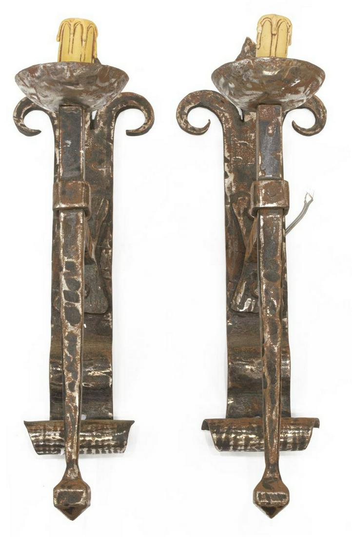 (2) GOTHIC STYLE HAMMERED STEEL WALL SCONCES: (lot of 2) Gothic style hammered steel wall sconces, 20th c., scrolled backplate with fleur-de-lis terminal, single faux candle over bobeche, on a tapered support, in need of wiring, approx 21"h, 5.75