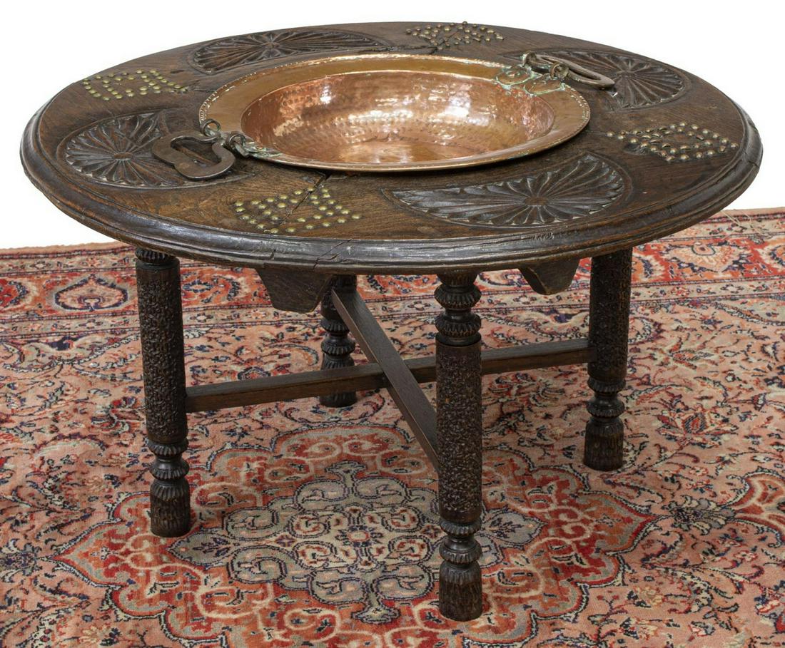 CONTINENTAL OAK BRAZIER TABLE W/ COPPER INSERT: Continental oak brazier table, late 19th c., circular tabletop with lunette carving, metal studs, inset hammered copper handled bowl, rising on carved cylindrical legs, joined by cross stretcher, appr