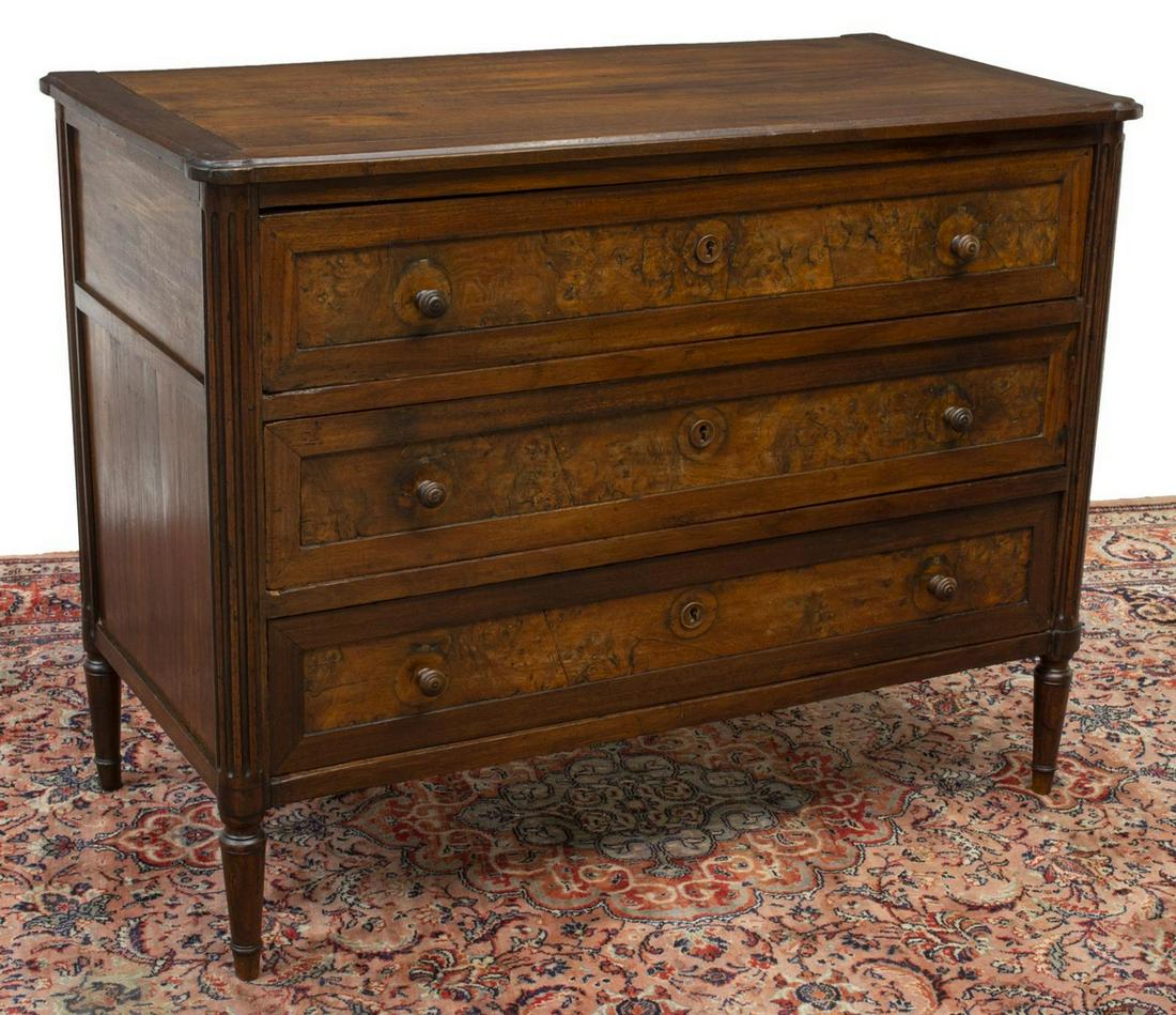 FRENCH LOUIS XVI STYLE WALNUT COMMODE, 19TH C.: French Louis XVI style walnut commode, 19th c., having rectangular top, fluted side columns, three drawers with burled panels, rising on tapered legs, approx 34"h, 43.5"w, 21.75"d Start Price: $350.00