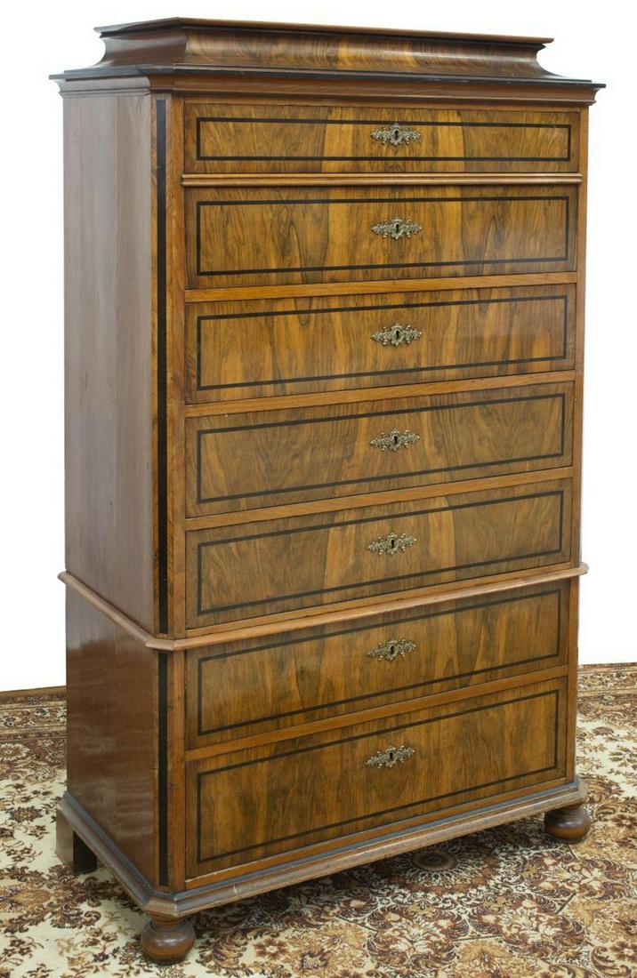 DANISH BIEDERMEIER FIGURED CHEST OF DRAWERS: Danish Biedermeier figured chest of drawers (semainier), 19th c., raised top, over tall canted case fitted with seven drawers, ebonized accents, elaborate matched escutcheon, on bun feet, approx 64"h,