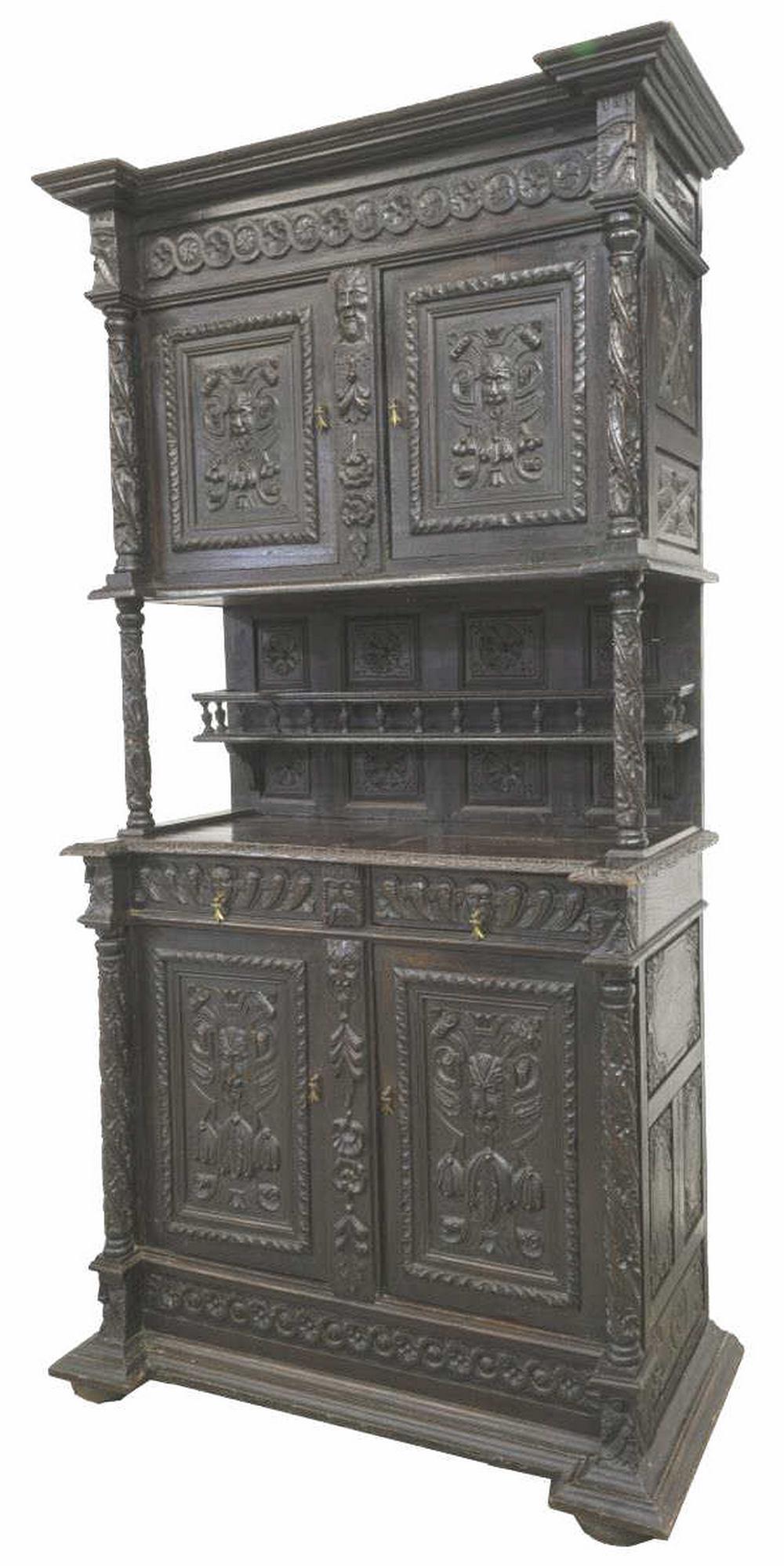 RENAISSANCE REVIVAL EBONIZED OAK SIDEBOARD: Continental Renaissance Revival oak sideboard, early 20th c., elaborately carved with running ornamentation, flowers, and masked figures in relief, double-door cabinet to top, plate rack, supported by