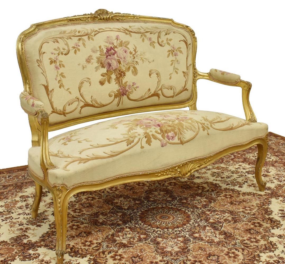 LOUIS XV STYLE GILTWOOD SALON SOFA SETTEE: Louis XV style sofa, upholstered in floral tapestry, having a giltwood frame with carved shell and foliate accents, with padded arms, rising on cabriole legs, ending in whorl feet, approx 40"h, 51.5"w